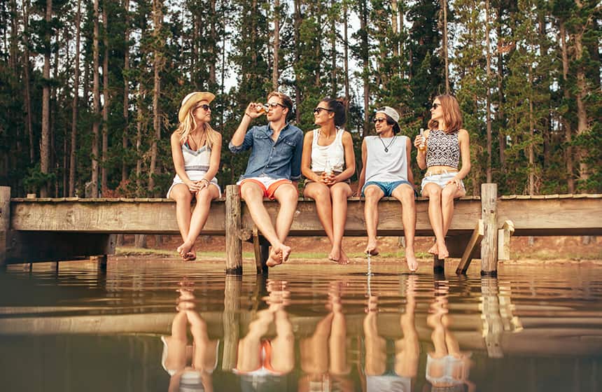 Eine Gruppe von Freunden sitzen am See