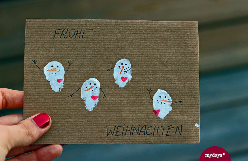Schneemänner auf einer braunen Karte als gebastelte Weihnachtskarte