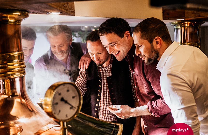 Fünf Männer schauen in einen Braukessel