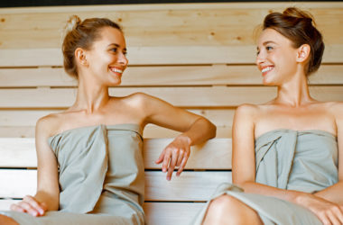 Zwei Frauen in der Sauna lächeln sich an