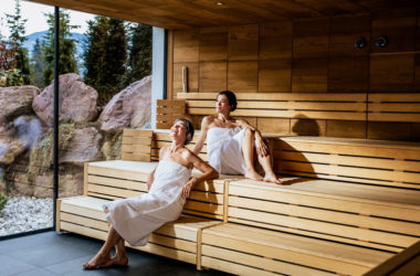 Zwei Frauen sitzen in de Sauna und unterhalten sich