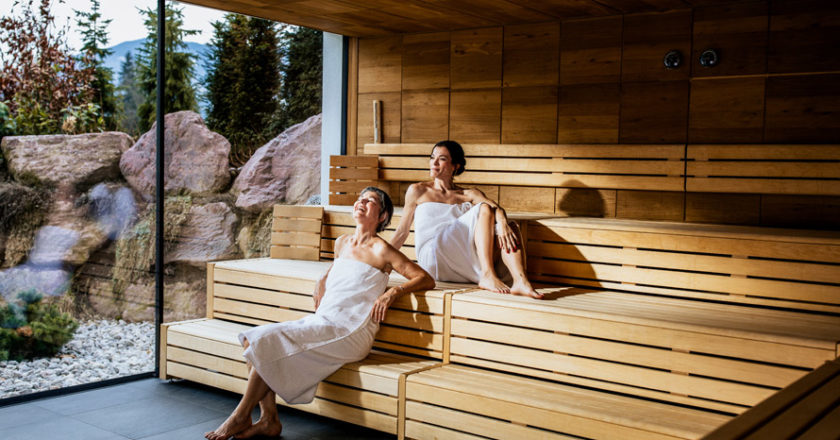 Zwei Frauen sitzen in de Sauna und unterhalten sich
