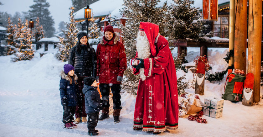 Weihnachtsmann spricht mit Familie im Schnee