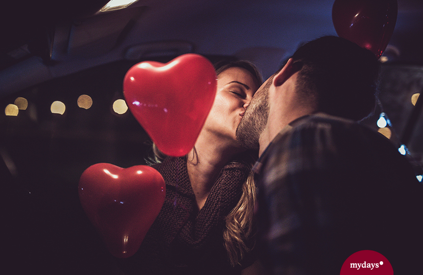 Paar küsst sich im Auto, Herzluftballon