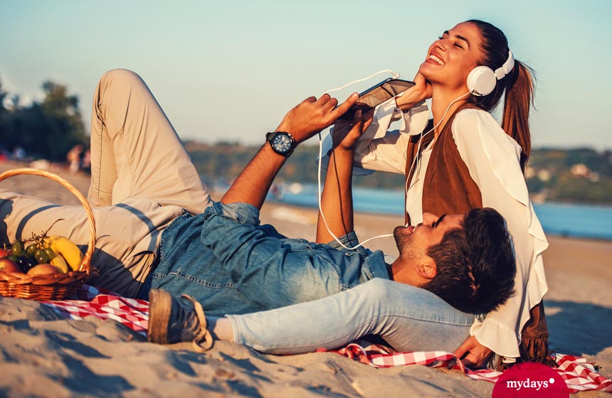 Paar hört Musik am Strand