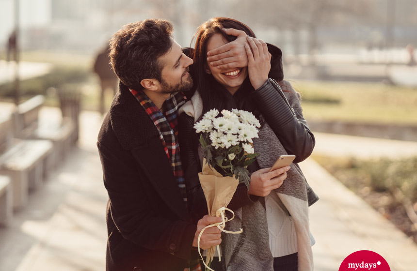 Mann überrascht Frau mit Blumen